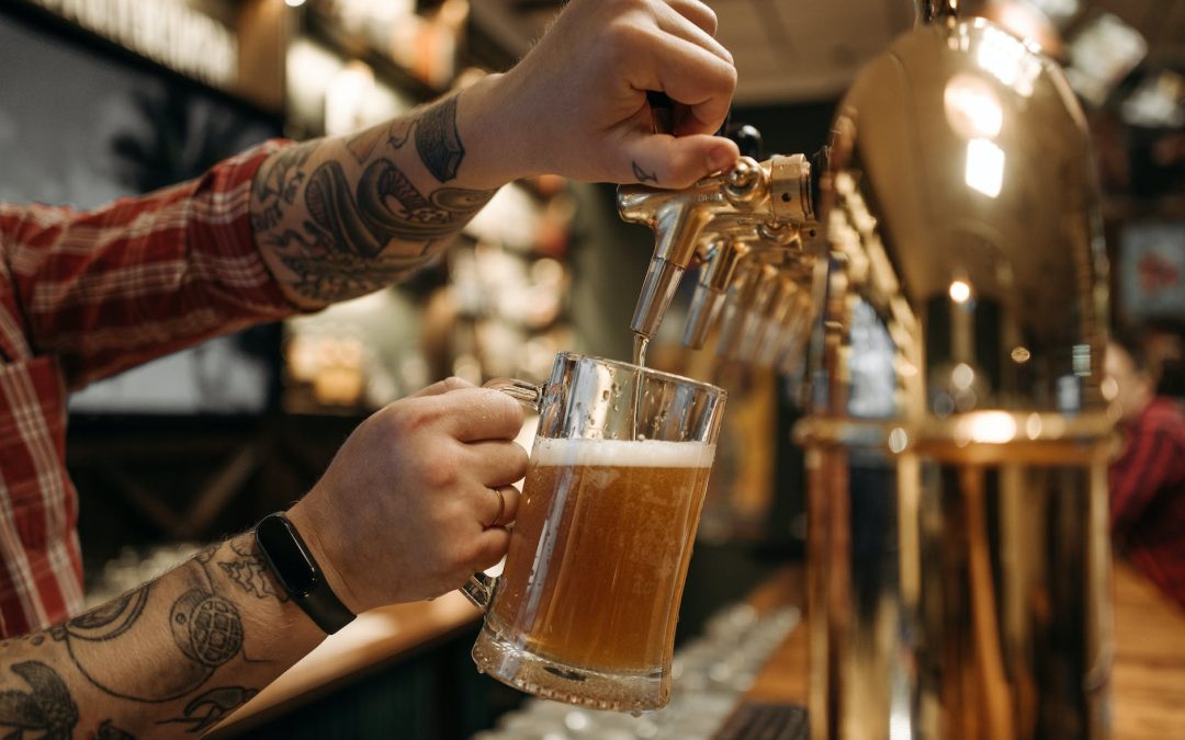 person holding clear drinking glass with beer